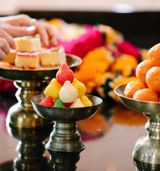 Colorful Indian sweets on brass platters, ideal for traditional celebrations.